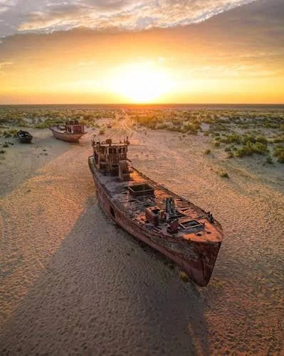 Rusting fishing trawlers standing on dry sand near Moynaq, more than a hundred kilometres from the present shoreline.