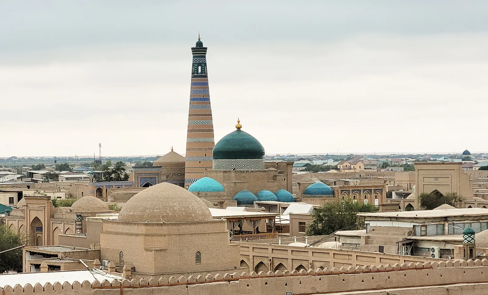Flat mud-brick rooftops and minarets inside the walled Itchan Kala, seen from the ramparts at dusk.